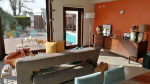 Un salon moderne avec un canapé, une table basse et une vue sur une piscine.