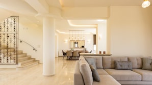 A spacious living area with a modern staircase, a dining area, and a large sofa. - Aelia Residence, Wellness & Leisure with 100m² Heated Pool, Whirlpool, Sauna&Gym (Rethymnon)