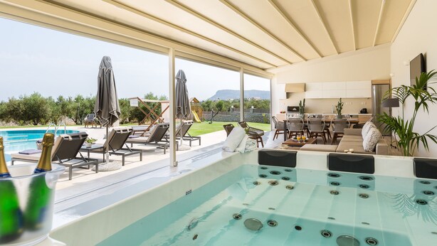 A modern outdoor pool area with lounge chairs, a hot tub, and a view of the landscape. - Aelia Residence, Wellness & Leisure with 100m² Heated Pool, Whirlpool, Sauna&Gym (Rethymnon)