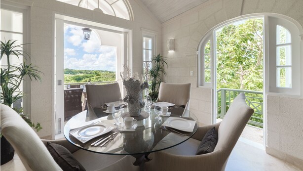 A dining area with a glass table, white chairs, and a decorative vase. - Sugar Cane Ridge 23 (St James)