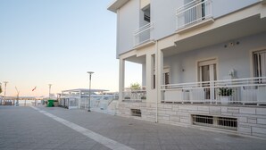 Un bâtiment à deux étages doté de balcons, d’une allée pavée et surplombant un ciel dégagé.
