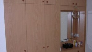 Un armario de madera con espejo y repisa.