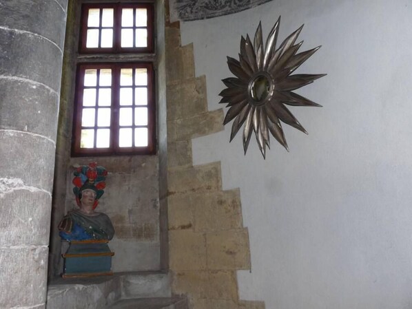 A staircase with a statue at the bottom, a window with bars, and a sunburst decoration on the wall. - Mansion - Charming cottage - SAOU (Saou)