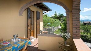 A balcony with a table set for breakfast, a chair, and a vase with flowers. - Spacious 5 bedroom villa with private pool, full wheelchair access with lift (Garfagnaana)