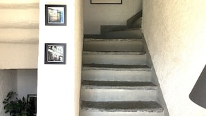 Un escalier avec un mur blanc et trois tableaux encadrés.