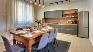 A modern kitchen with a built-in oven, a stainless steel refrigerator, and a dining area with a wooden table set for four. - Heated pool, whirlpool, 3 km from the sea, barbecue, WiFi, free WLAN (Pula)