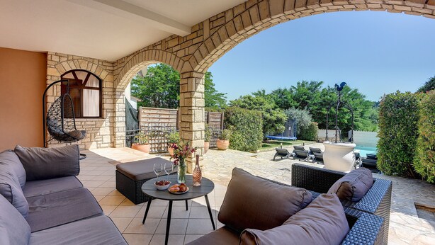 A covered outdoor seating area with stone arches, a pool, and lush greenery in the background. - Heated pool, whirlpool, 3 km from the sea, barbecue, WiFi, free WLAN (Pula)