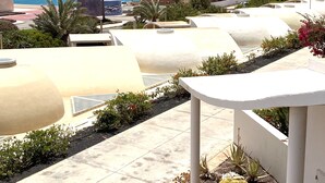 A rooftop terrace with a view of the sea, palm trees, and modern buildings. - Pool, few min from the sea, protected inner courtyard (Fuerteventura)