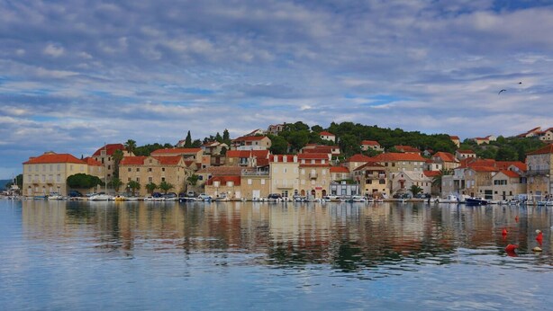 A waterfront with buildings, boats, and a clear sky.
