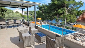 An outdoor pool area with wicker furniture and umbrellas.