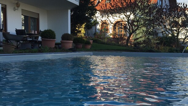 A swimming pool with a house in the background. - Comfortable apartment with pool for 2-6 people (110 sqm) (Ranschbach)
