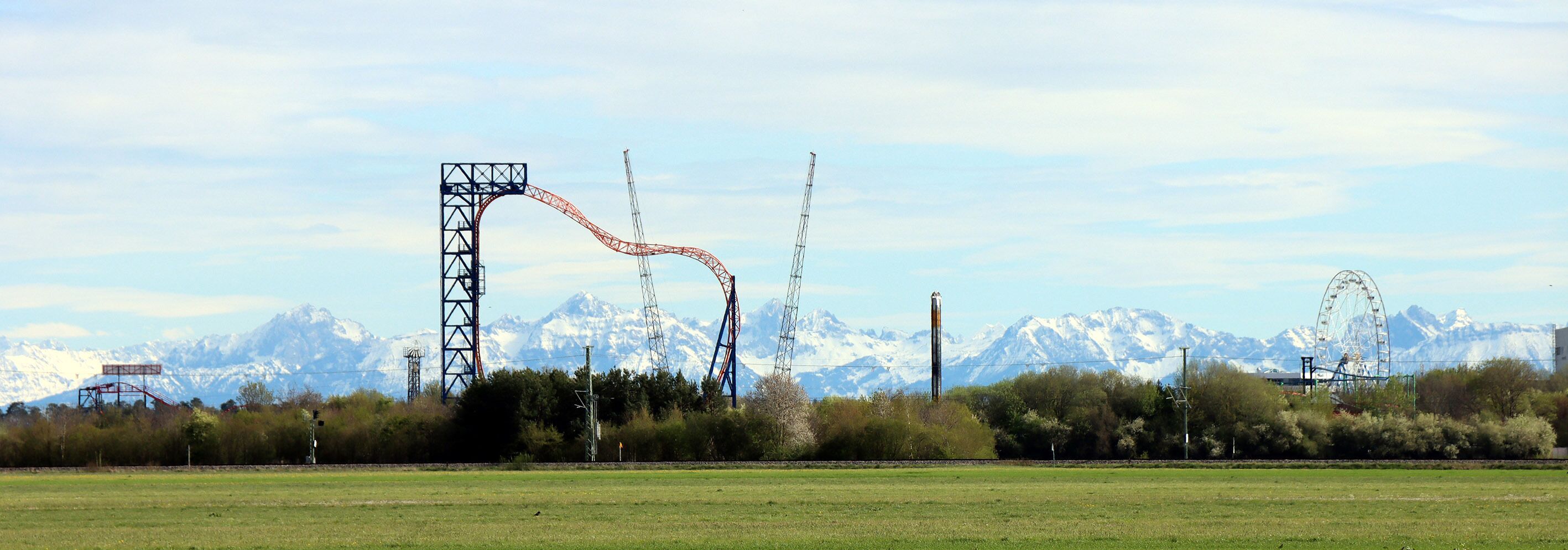 A roller coaster with a mountainous backdrop.