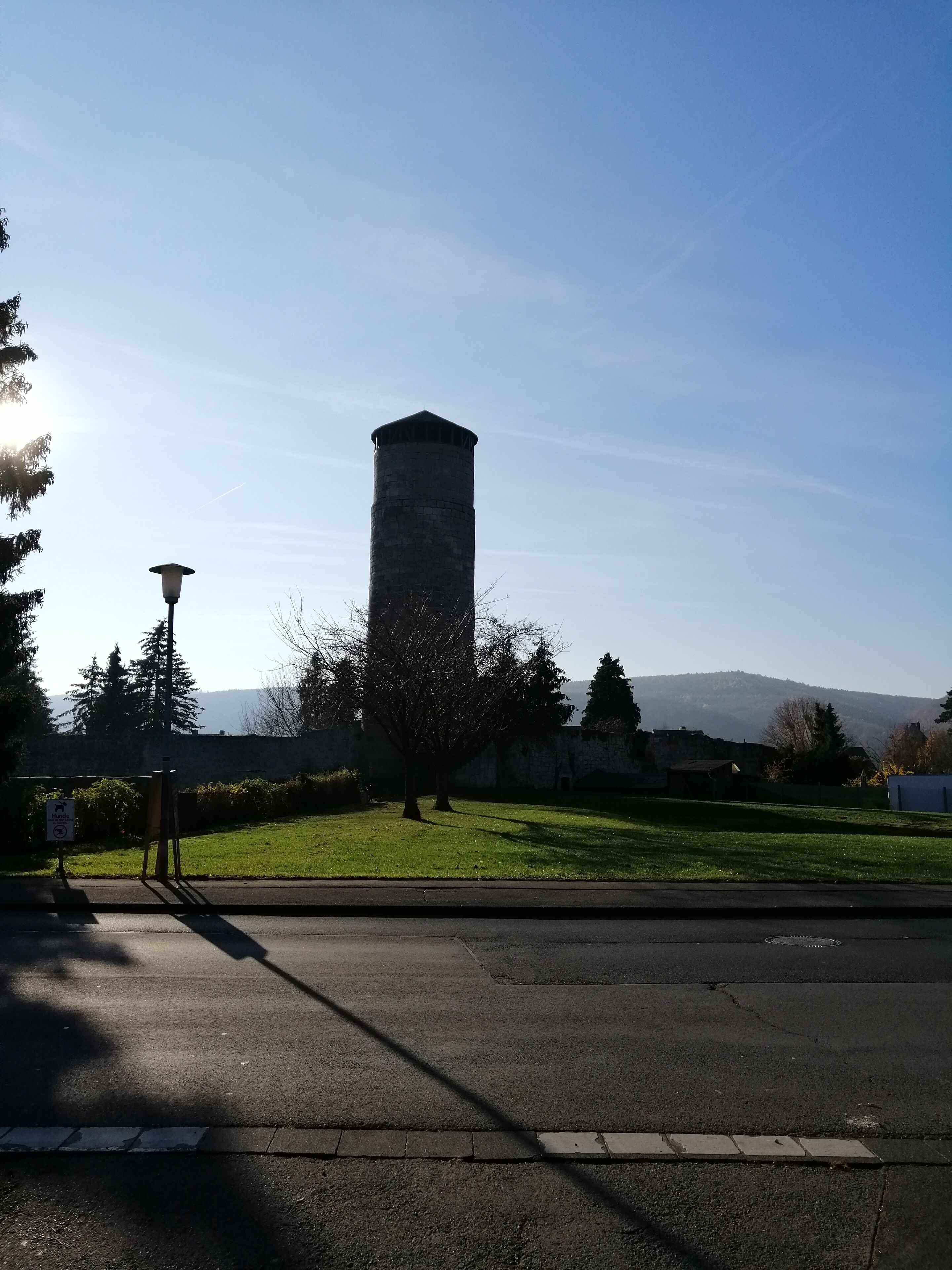 A tall stone tower in a park with a clear sky.