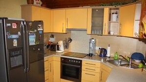 A compact kitchen with a refrigerator, oven, and sink. - Cozy holiday apartment in Kirchlengern in a quiet residential area (Kirchlengern)