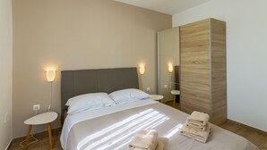Een moderne hotelkamer met een groot bed, nachtkastjes en een kledingkast.