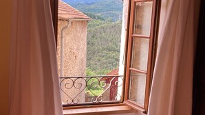 A room with a window overlooking a mountainous landscape.