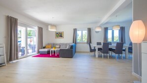 Un salon moderne avec un canapé, une table basse et un coin repas.