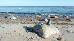 A pebbled beach with large rocks and a stack of stones in the foreground. - Ren. Apartment on the ground floor, WiFi, close to the beach, partially fenced, children-u. tierfreundl. (Börgerende-Rethwisch)