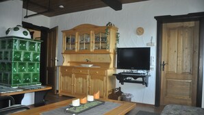 Una sala acogedora con un aparador de madera, un televisor y un mueble de almacenamiento verde.