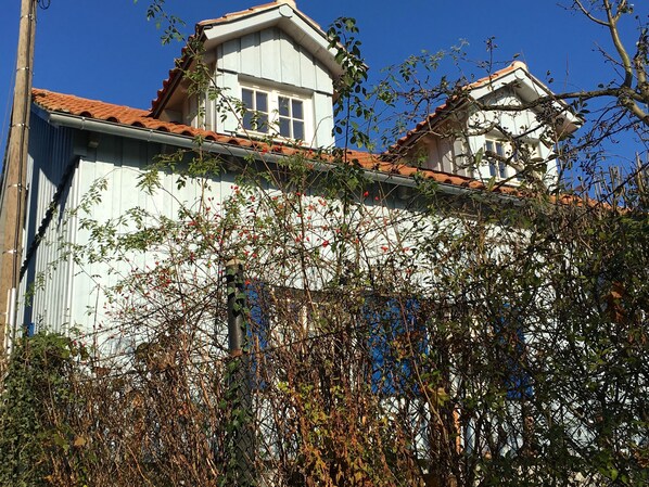A two-story building with a white facade and red-tiled roof.