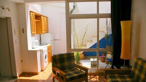 Un espace de vie compact comprenant une cuisine, un canapé, une chaise et une table.
