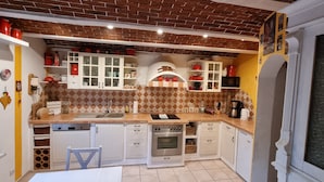 A compact kitchen with white cabinets, a built-in oven, and a microwave. - Detached house, fireplace, huge garden, small stream, idyllic, tranquillity, pure nature (Mittenwalde)