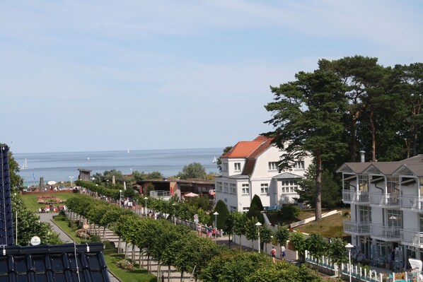 Een hotel aan de kust met een balkon, een tuin en uitzicht op zee.