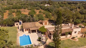 Une villa de style méditerranéen dotée d’une piscine, d’un jardin aménagé en terrasses et offrant une vue sur les montagnes.