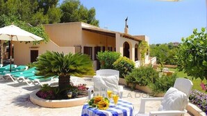 Un complexe hôtelier doté d’une terrasse, d’une piscine et d’un bâtiment orné d’arcades.