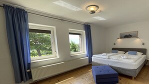 Una camera da letto con un letto, una finestra, un termosifone e una luce a soffitto.