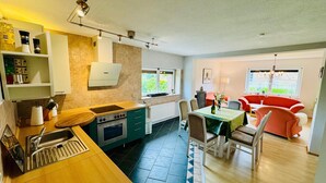 Una cucina compatta con lavello, fornelli e zona pranzo con sedie e tavolo.