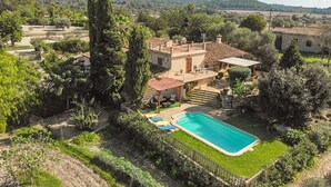 A villa with a swimming pool, surrounded by lush greenery and hills in the background. - Finca Son Rebassa (Sant Joan)