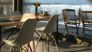 A modern dining area with a view of a snowy landscape through large windows.