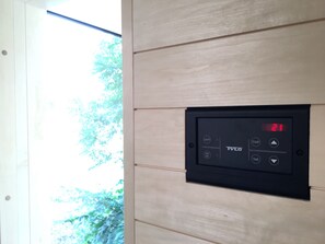 A control panel with a digital display, light switch, and temperature control on a wall. - "Finca Baltica": Baltic Sea dream vacation on 3500 sqm with an exclusive sauna house (Wichmannsdorf)