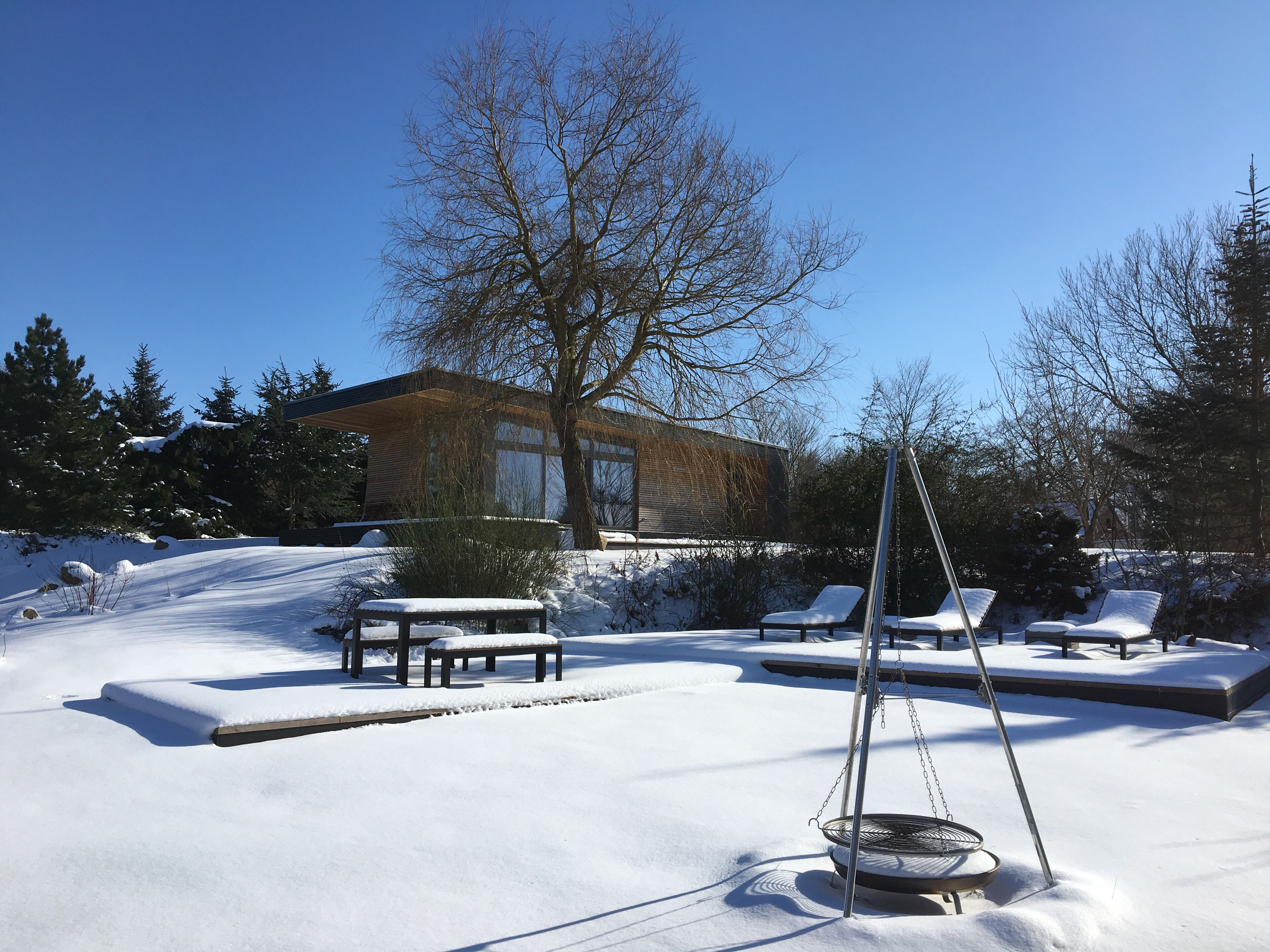 A snow-covered outdoor area with benches and a swing set.