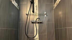 A shower with a handheld showerhead and a wall-mounted control panel. - the gites les chênes n. 2, private pool and spa (Servas Gard)