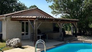 A pool with a wooden deck and a covered patio area. - the gites les chênes n. 2, private pool and spa (Servas Gard)