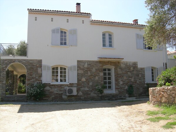 A two-story building with a stone facade, white shutters, and a tiled roof. - Villa for 8/10 people, 10 minutes' walk from the beach, air-conditioned. Quiet neighborhood. (L'île-Rousse)
