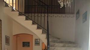 A staircase with a black railing and a chandelier above.