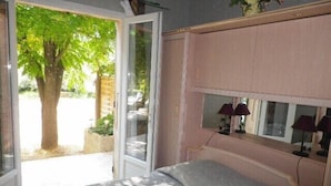A bedroom with a bed, a window, and a mirror. - Villa sleeps 8, 2 shower rooms, summer kitchen, heated pool, shaded parking. (Mornas)