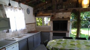 A kitchen with a sink, cabinets, and a dining area with a table and chairs. - Villa sleeps 8, 2 shower rooms, summer kitchen, heated pool, shaded parking. (Mornas)
