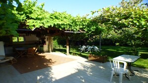 A patio area with a pergola, outdoor seating, and a grill. - Villa sleeps 8, 2 shower rooms, summer kitchen, heated pool, shaded parking. (Mornas)