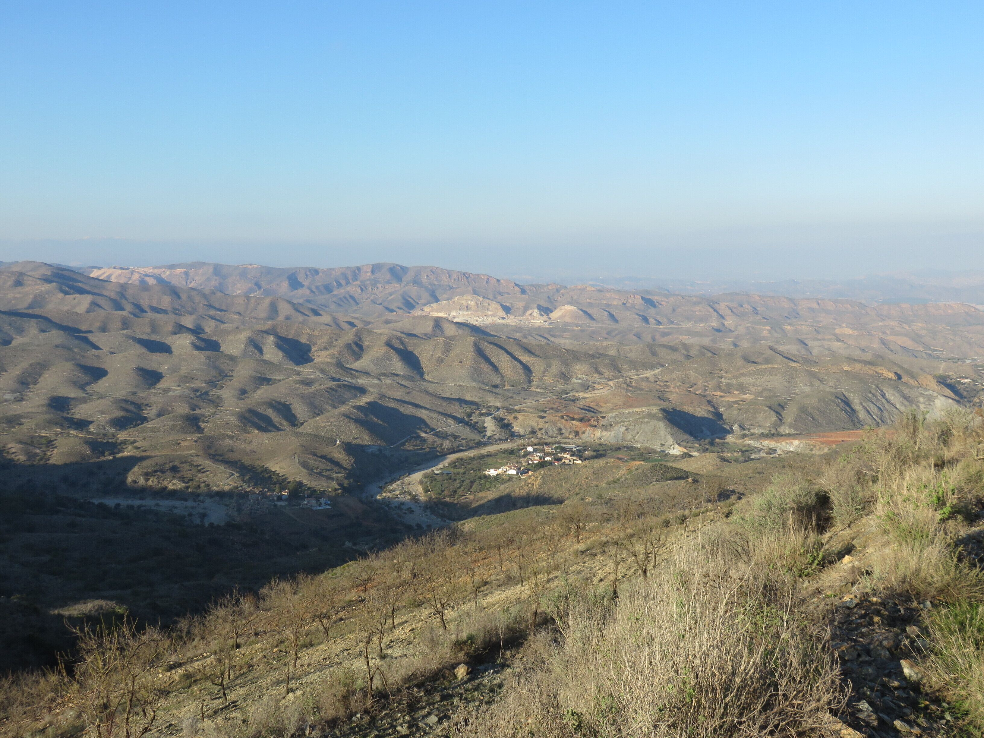 A mountainous landscape with a small settlement in the valley.