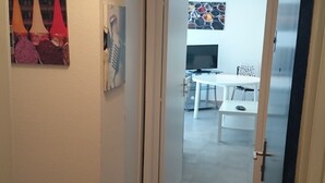 A hallway leading to a dining area with a table and chairs. - Apartment seafront luxury building Canet Sud, parking and free WIFI (Canet-En-Roussillon)