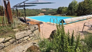 A swimming pool with a stone wall and a wooden deck. - Charming old house with private SPA and swimming pool, estate in nature park (Les Pechs Du Vers)