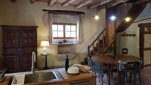 A rustic kitchen with a wooden table, a sink, and a window with curtains. - Charming old house with private SPA and swimming pool, estate in nature park (Les Pechs Du Vers)