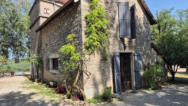 A stone building with a tiled roof, a wooden door, and a small window. - Charming old house with private SPA and swimming pool, estate in nature park (Les Pechs Du Vers)