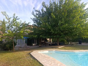 A backyard with a swimming pool, a tree, and a house. - Family villa in the heart of Provence with swimming pool, garden Up to 10 people (Saint-Cannat)