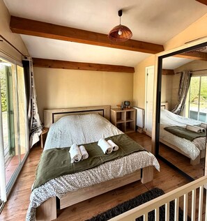 A bedroom with a bed, a bedside table, a mirror, and a window. - Family villa in the heart of Provence with swimming pool, garden Up to 10 people (Saint-Cannat)