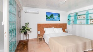 Ein Schlafzimmer mit einem Bett, einem Nachttisch, einem an der Wand befestigten Regal, einem Gemälde und einer Topfpflanze.